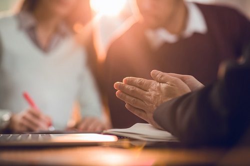 Close up of unrecognizable financial advisor rubbing his hands while made a fraud on his clients.